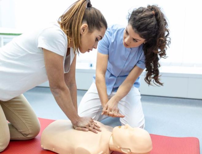 Woman training someone how to do CPR